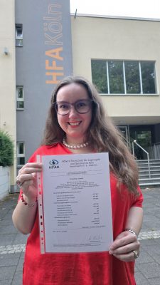 Franziska Lampen mit Semester-Zeugnis vor der HFAK